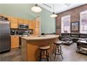 Bright open kitchen with a stainless steel refrigerator, stainless appliances, breakfast bar, and exposed brick at 350 Peters Sw St # 3, Atlanta, GA 30313