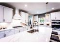 White kitchen with marble countertops and a large island at 715 Crossroad Ct, Powder Springs, GA 30127