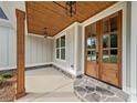 Inviting front porch with a wooden door and stone accents at 220 Autumn Brook Dr, Canton, GA 30115