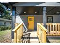 Inviting front porch with yellow door and wooden railings at 1043 Smith Sw St, Atlanta, GA 30310