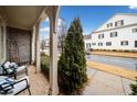Covered front porch with brick flooring, bench, and a view of the street at 228 Dawson Dr, Woodstock, GA 30188