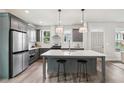 Contemporary kitchen featuring gray cabinetry, stainless steel appliances, and a spacious island with bar seating at 3846 Cottage Cir, Clarkston, GA 30021