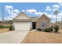 Brick and gray siding ranch home with attached garage and landscaping at 7250 Lacey Dr, Douglasville, GA 30134