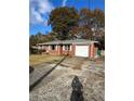 Brick ranch house with attached garage and a gravel driveway at 1261 Cliffwood Se Dr, Smyrna, GA 30080