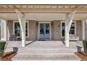 Covered front porch with stone flooring, blue double doors, and decorative seating at 165 Grayton Ln, Roswell, GA 30075