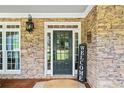 Stone front porch with a dark-green door and welcome sign at 4805 Blossom Ct, Cumming, GA 30028