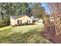 Side view of a yellow ranch home with mature trees and landscaping at 1237 Torrey Pl, Dacula, GA 30019