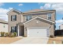 Two-story brick home with a white two-car garage and landscaped lawn at 4169 Wood Fern Ln, Buford, GA 30519