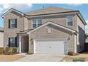 Two-story brick home with a white two-car garage and landscaped lawn at 4169 Wood Fern Ln, Buford, GA 30519