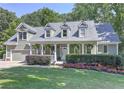 Two-story house with a wrap-around porch and landscaped yard at 5032 Hickory Hills Dr, Woodstock, GA 30188