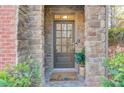 Inviting front door entry with stone accents and welcome mat at 588 Myrtle Trace Ln, Suwanee, GA 30024