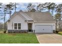 White farmhouse style home with gray stone accents and a two-car garage at 512 Altamaha Ct, Locust Grove, GA 30248