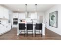 Modern kitchen with white cabinets, an island with black stools, and stainless steel appliances at 512 Altamaha Ct, Locust Grove, GA 30248