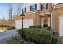 Attractive townhouse entrance with landscaping and black front door at 2128 Mill Garden Run, Buford, GA 30519