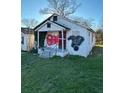 White bungalow with overgrown vines and graffiti, needing renovation at 654 English Nw Ave, Atlanta, GA 30318