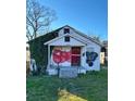 White bungalow with overgrown vines and graffiti, needing renovation at 654 English Nw Ave, Atlanta, GA 30318