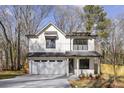 Two-story farmhouse-style home with white siding, gray roof, and attached garage at 3208 Altacrest Dr, Scottdale, GA 30079