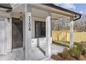 Covered front porch with white columns and gray door at 3208 Altacrest Dr, Scottdale, GA 30079