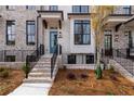 Beautiful exterior of a brick townhome featuring a blue door, black windows, and manicured landscaping at 550 Fisher Dr # 47, Alpharetta, GA 30009