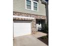 Attached garage with white door and brick facade at 137 Swindon Dr, Mcdonough, GA 30253