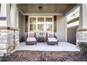 Relaxing front porch with wicker chairs, side table, and view of landscaping at 340 Glens Way, Woodstock, GA 30188