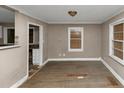 Large living room with laminate wood flooring and damaged areas at 4175 Cottage Ln, Conley, GA 30288