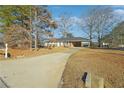 Front view of a ranch home with a long driveway at 8586 Taylor Rd, Riverdale, GA 30274