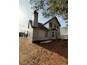 Unfinished house exterior, rear view, showcasing a chimney and yard at 2615 Virginia Cv, Riverdale, GA 30296