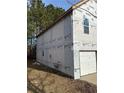 Unfinished house exterior with white siding and a single garage door at 2615 Virginia Cv, Riverdale, GA 30296