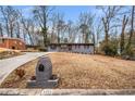 View of the front exterior and driveway of the home, set on a lot with mature trees at 2725 Shoreland Sw Dr, Atlanta, GA 30331