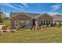 Inviting brick home with lush landscaping and a well-maintained lawn, bathed in sunlight at 5424 Flat Rock Point, Stonecrest, GA 30038