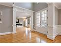 Inviting foyer with hardwood floors, decorative columns, wainscoting, and double french doors at 745 Glengate Pl, Atlanta, GA 30328