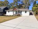 Front view of a renovated home featuring a concrete driveway and updated landscaping at 1912 Canmont Ne Dr, Atlanta, GA 30319