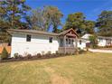 Charming updated home with white brick exterior, a covered porch, and a well-manicured lawn at 1912 Canmont Ne Dr, Atlanta, GA 30319