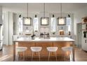 Modern kitchen with light wood island, white cabinets, and pendant lights at 731 Belt Se Loop, Atlanta, GA 30316