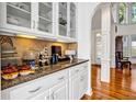 White kitchen cabinets, granite countertops, and glass-front cabinets at 4685 Jailette Trce, Atlanta, GA 30349