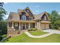 House exterior showcasing a two-story home with a stone and shingle facade, plus a three-car garage at 15 Amberly Ln, Cartersville, GA 30121