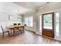 Light-filled dining room with hardwood floors and a wooden table illuminated by a decorative chandelier at 137 Woodfin Way, Social Circle, GA 30025