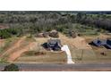 Aerial shot of a gray home on a large lot, showcasing the driveway, landscaping, and surrounding wooded area at 181 Woodfin Way, Social Circle, GA 30025