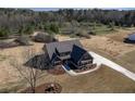 Aerial view of gray home featuring a long driveway, landscaping, and expansive land at 181 Woodfin Way, Social Circle, GA 30025