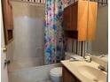 Bathroom with floral shower curtain and wood cabinets at 3754 Sidney Lanier Blvd, Duluth, GA 30096
