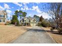 Charming two-story home with a well-manicured front yard and a long driveway leading to a two-car garage at 5025 Hidden Ct, Cumming, GA 30040
