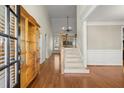 Inviting foyer with hardwood floors, a staircase with iron railings, and a decorative cabinet at 5025 Hidden Ct, Cumming, GA 30040