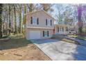 Tan house with red door, attached garage, and landscaped yard at 3794 Whaley Ct, Snellville, GA 30039