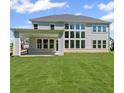 Expansive backyard featuring lush green grass and a covered patio, perfect for outdoor entertaining at 6745 Dahlgren Ct, Cumming, GA 30028