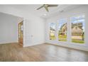 Sunlit bedroom with hardwood floors, white walls, and large windows overlooking the front yard at 6745 Dahlgren Ct, Cumming, GA 30028