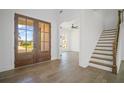 Bright entryway featuring hardwood floors, a staircase, and large glass double doors at 6745 Dahlgren Ct, Cumming, GA 30028
