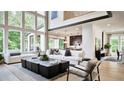 Spacious living room with hardwood floors, large windows, and modern furniture at 6745 Dahlgren Ct, Cumming, GA 30028