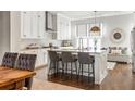 Open concept kitchen with island seating, white cabinets, and hardwood floors at 120 Clover Ct, Roswell, GA 30075