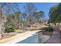 Spacious front yard with mature trees and a long driveway, offering a serene and private setting at 5545 Woodsong Trl, Dunwoody, GA 30338